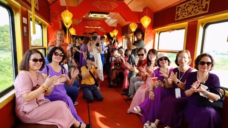 Passengers share joyful moments after unexpectedly meeting one another on a train journey. (Photo: nhandan.vn)